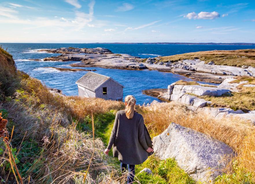 A person standing on the edge of the ocean on Sambro Island.